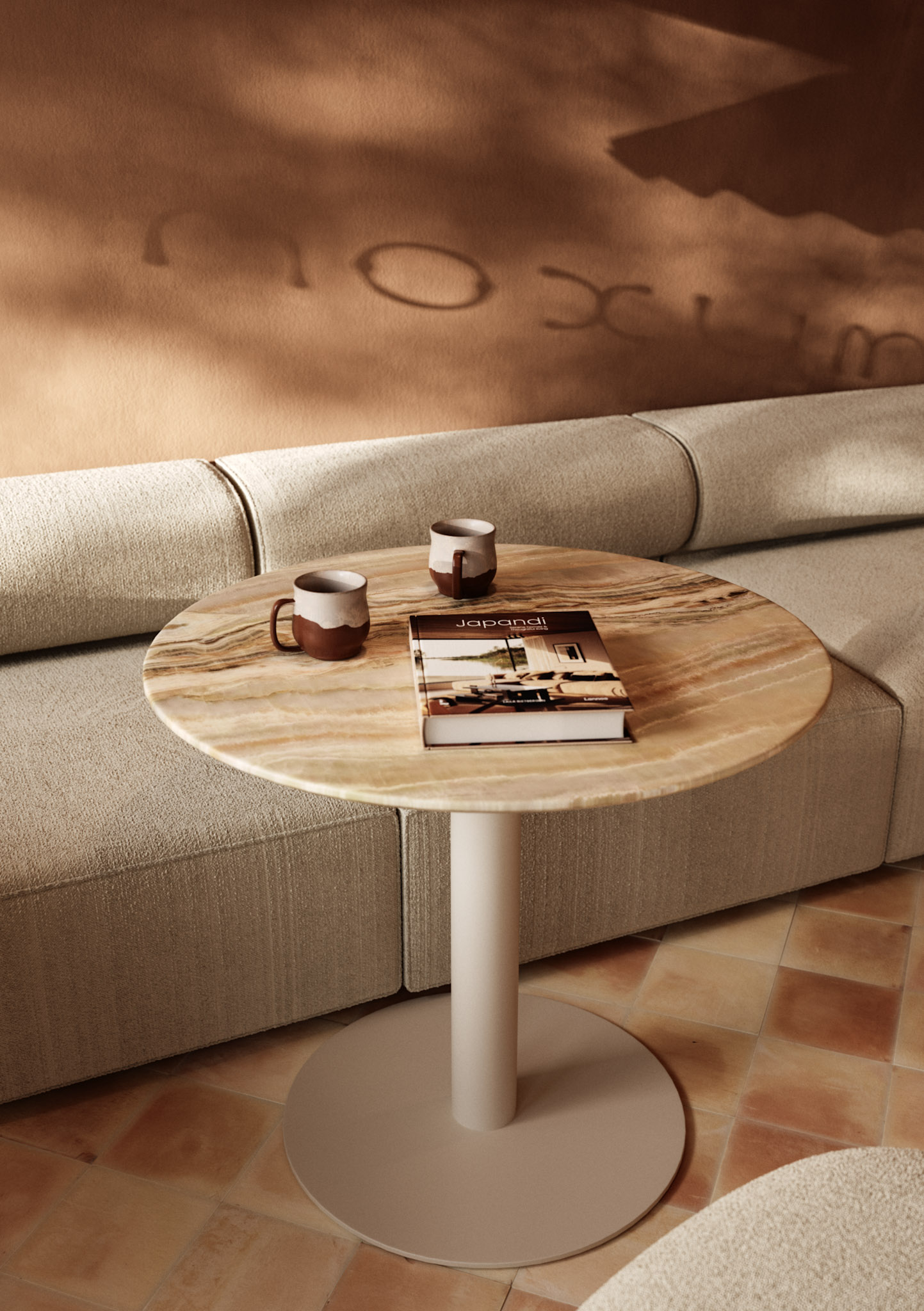 Cafetería de Noxum con asientos tapizados bajos. Mesas en piedra con tazas artesanales. Pared en pintura a la cal terracota con iluminación cálida con sombras.